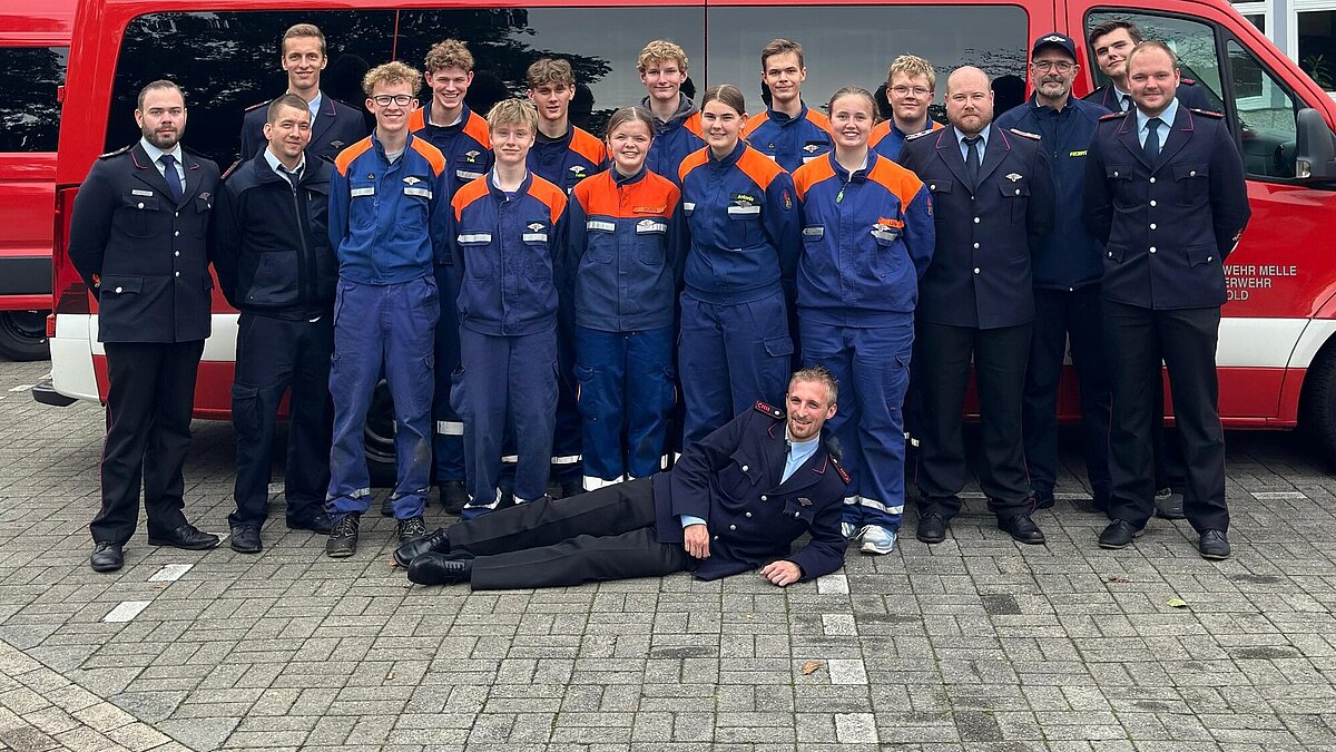 Gruppenfoto der Jugendlichen mit Ausbildern vor einem Feuerwehrfahrzeug